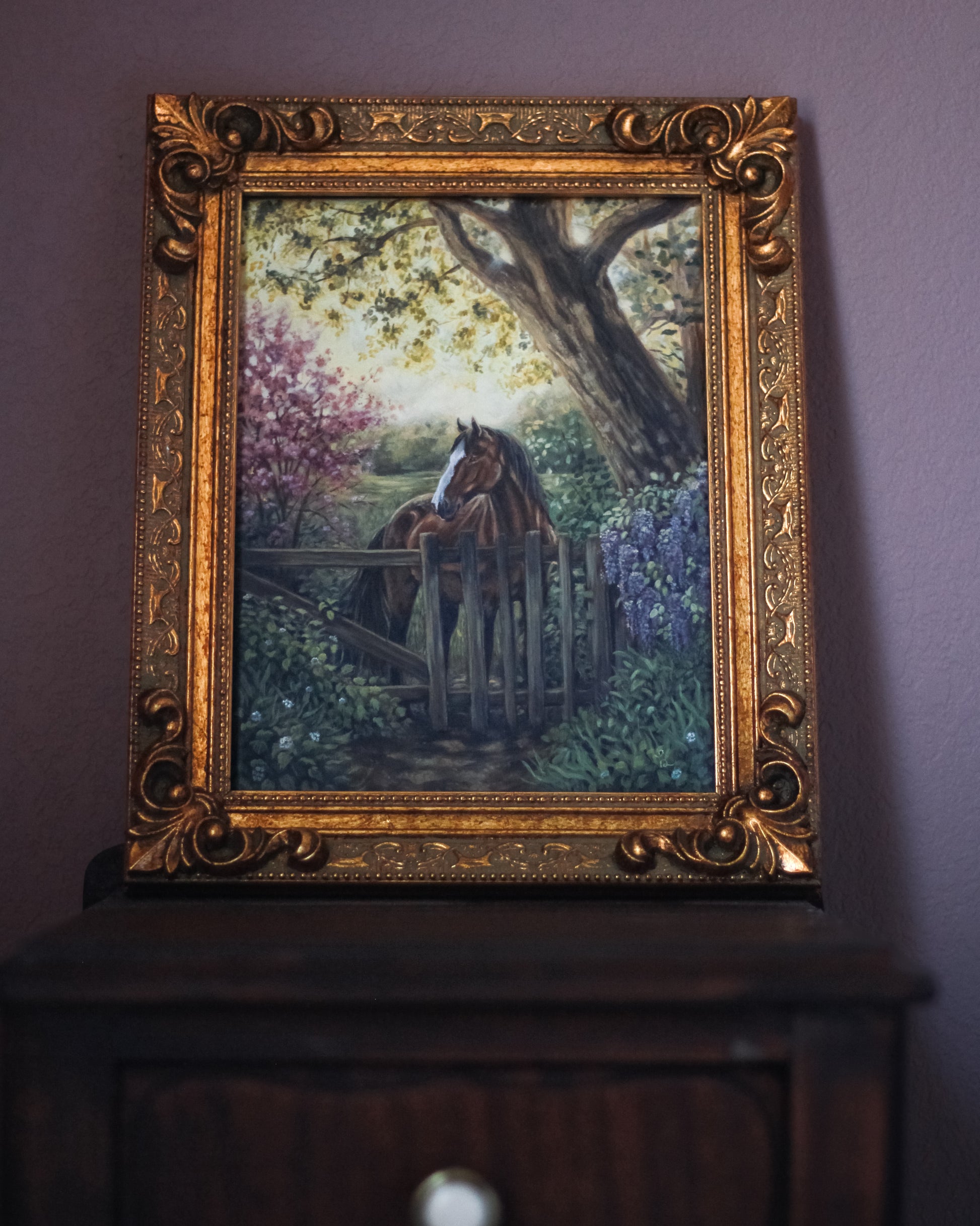 Framed painting of a horse by a fence on a purple wall